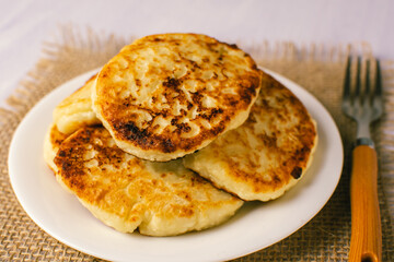 Cottage cheese pancakes with sour cream on white background, breakfast or lunch