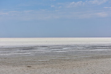 Landscape of a deserted salt lake. The texture of salt formations in the foreground. salt lake surface, dry salt lake, white salt lake