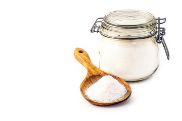 Glass jar and wooden spoon with baking soda on isolated white background, chemical compound in...
