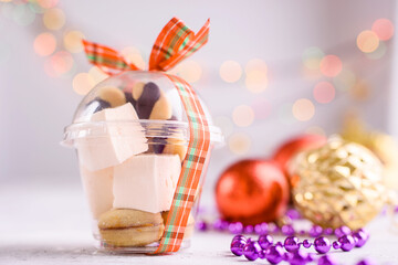 Box with satin ribbons and delicious treats for New Year and Christmas. New Year's desserts on a light background.
