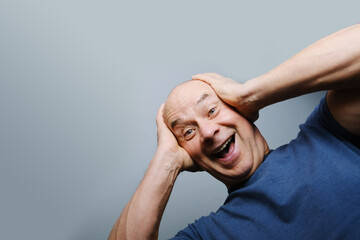 elderly man raised her hands in surprise and joy, bright emotions on her face, the concept of a...