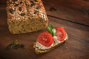 Tomatoes, basil and cream cheese on homemade protein bread from lupine flour, oat bran and pumpkin...