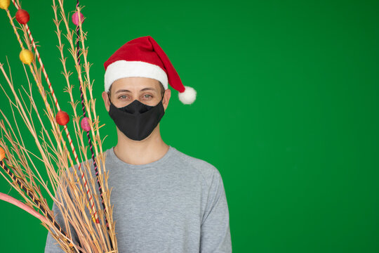 Joven con gorro navide&ntilde;o y tapabocas