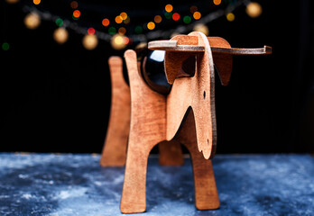 A wooden stand for a bottle of wine, in the form of a symbol of the new year, in the form of a bull. New Year's lights