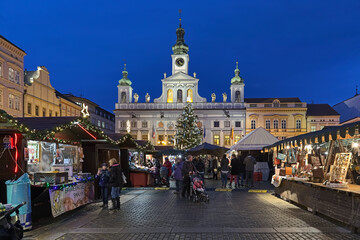 Ceske Budejovice, Czech Republic. Christmas market at the Premysl Otakar II Square with city's main Christmas tree on the background of the old Town Hall in twilight.