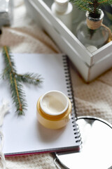 Details of still life in the home interior living room. Orange Opened plastic container, jar.of cream over Christmas lights bokeh in home. holiday decoration, magic Christmas. Selected focus