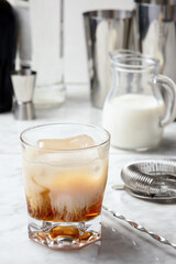 White Russian cocktail preparation. Cream mixing with vodka and coffee liqueur