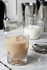 Famous White Russian Cocktail with Vodka, Coffee Liquor and Cream on a marble table