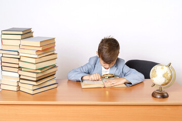 The student does homework, reads a book with a magnifying glass.