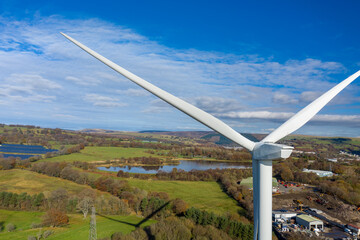 Aerial View of large wind turbine stationary on beautiful welsh landscape. clean energy concept