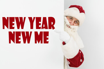 Santa Claus points his fingers at the board with the text - NEW YEAR NEW ME