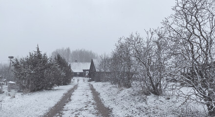 Winter landscape. Rural house buildings and snow covered fields.