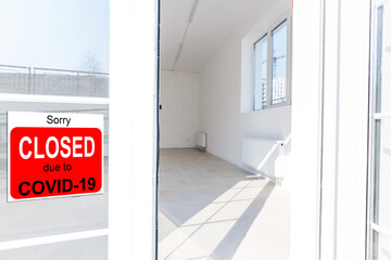 Business center closed due to COVID-19, sign with sorry in door window. Stores, restaurants,...