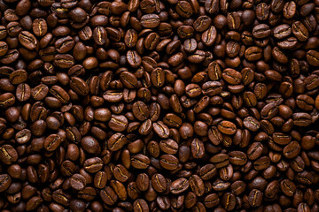 coffee beans background. Overhead macro shot of coffee seeds. Flat lay of the roasted coffee beans