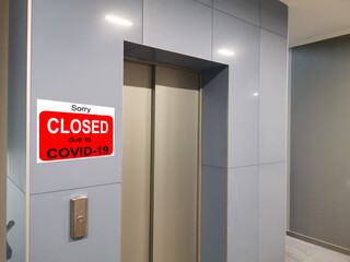 Business center closed due to COVID-19, sign with sorry in door window. Stores, restaurants,...