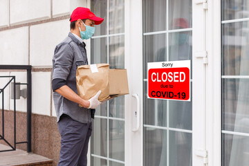 Business center closed due to COVID-19, sign with sorry in door window. Stores, restaurants,...