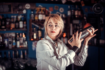 Girl bartender concocts a cocktail at the bar