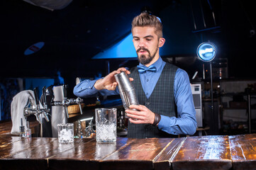 Professional Female bartender intensely finishes his creation  