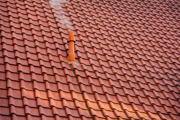 Rauch am Schornstein mit rotem Ziegeldach