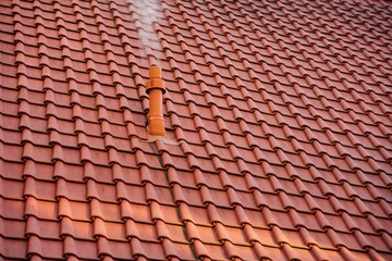 Rotes Dach mit Ziegel und Schornstein für die Heizung