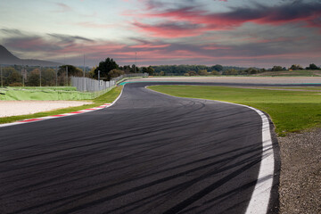 Black brake marks on asphalt in motor sport circuit going towards turn - obrazy, fototapety, plakaty
