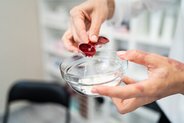 Close up on hands of female beautician cosmetologist preparing beauty mask treatment at spa salon - Front view midsection with copy space