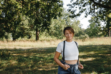 Leather belts. Professional photographer's unloading system on the back in the work. Portrait of the photographer, a woman stands with her face and looks to the left with a camera, uniform