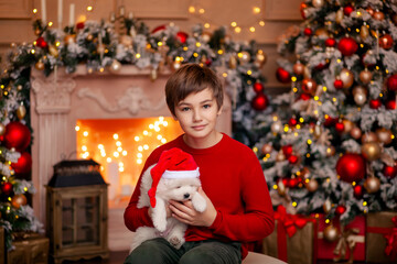 Cute baby boy at the christmas tree with a dog waiting for merry christmas