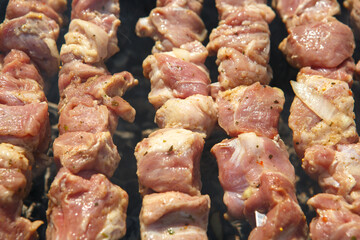 Raw pork meat skewers on wooden skewers close up