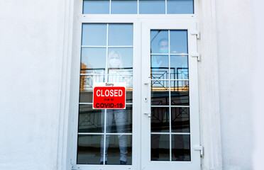 Business center closed due to COVID-19, sign with sorry in door window. Stores, restaurants,...