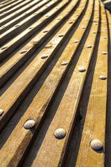 long planks horizontal, distant perspective with iron rivets in the sunlight