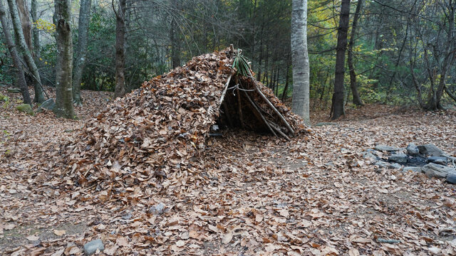 Survival Shelter Debris hut in the wilderness. Bushcraft camp setup in the forest.