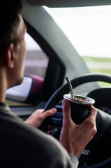 man driving drinking mate on the way to his travel destination on summer vacation

