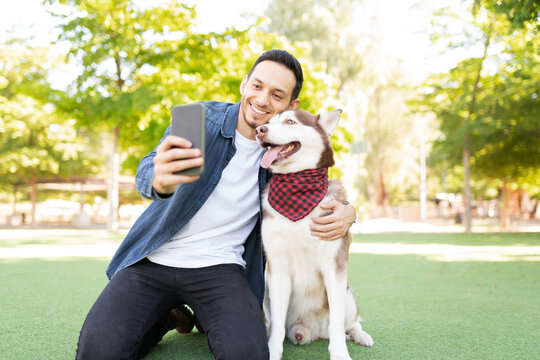 Latin dog owner taking a selfie with his big dog