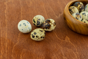 small quail eggs on a wooden bowl background close-up