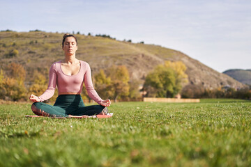 Woman practicing yoga in the park - relaxing in nature