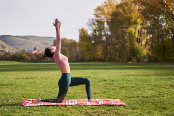 Woman practicing yoga in the park - relaxing in nature
