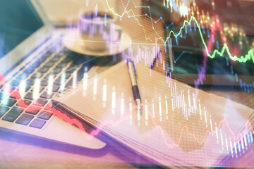 Double exposure of forex chart drawing and desktop with coffee and items on table background. Concept of financial market trading