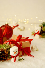 Christmas background. Gift boxes, marshmallow snow man, winter decorations, snow and bokeh lights.