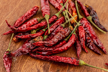 chili pepper hot pod red heap on wooden table seasoning background