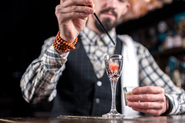 Experienced Female bartender makes a cocktail on the bar