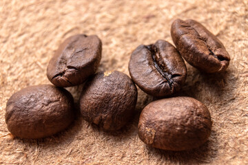 selective focus of raosted grains brazilian coffee on wooden background in Brazil