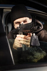 Fototapeta na wymiar Man with assault carbine waiting for his wictim inside car
