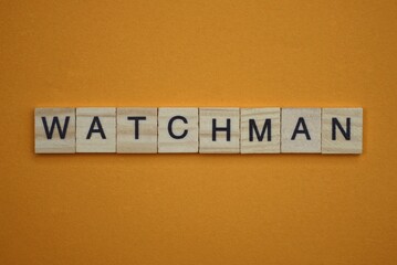 gray word watchman made of wooden square letters on brown background