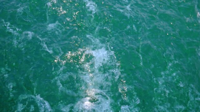 Wave pattern on water surface formed after forward moving boat. Full screen.