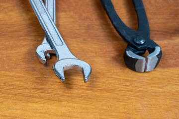 set of tools for repairing a wrench and wire cutters lies on a wooden table of the master