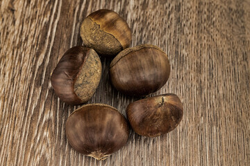 Obraz premium handful of brown edible chestnut on a wooden table