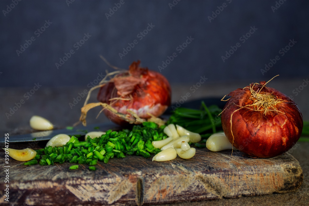 Sticker Closeup of sliced onion chives, garlic, and onions on a wooden chopping board