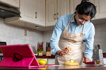 man in a kitchen, putting orange juice in a bread dough