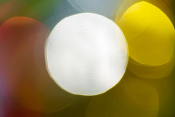 Happy New Year ornament decorations, colorful defocused abstract blurry bokeh background. Out of focus Xmas holiday lights, celebration motion blur texture, lens flare photo effect.